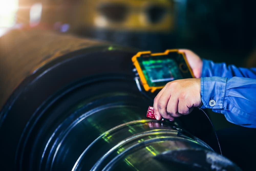 Technician performing non-destructive testing on a metal component